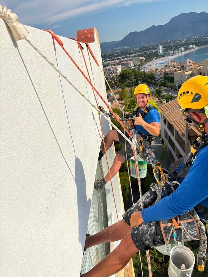 Dos operarios de AV Mantenimiento Integral trabajando descolgados en la fachada de un edificio de la Costa Blanca